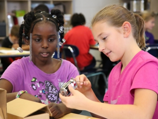 Two young students investigate a museum object.